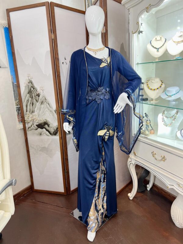 A jersey dress with embroidery and a short abaya  (the design becomes Hashemi) in tulle with embroidery of the poet's poem (Lamia Amara) Sing for Baghdad and the song (Above the Palm )from the back